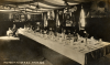 The barrack room of 74 and 78 Companies, Army Service Corps, in 1910, showing typically lavish decorations and the dining table laid ready for Christmas dinner.